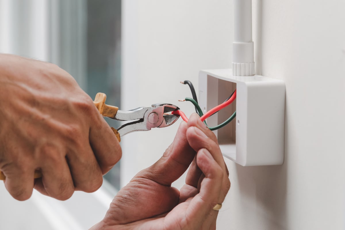 Electrician Repairing the Electric Outlet with Pliers